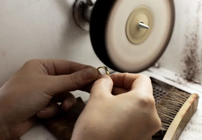 Mains d&#39;artisane en plein travail de polissage d&#39;une bague