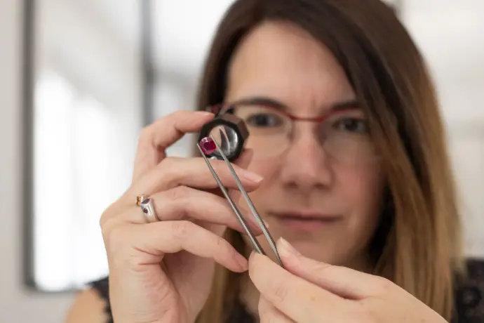 Visage de la joaillière en train de regarder un rubis à la loupe