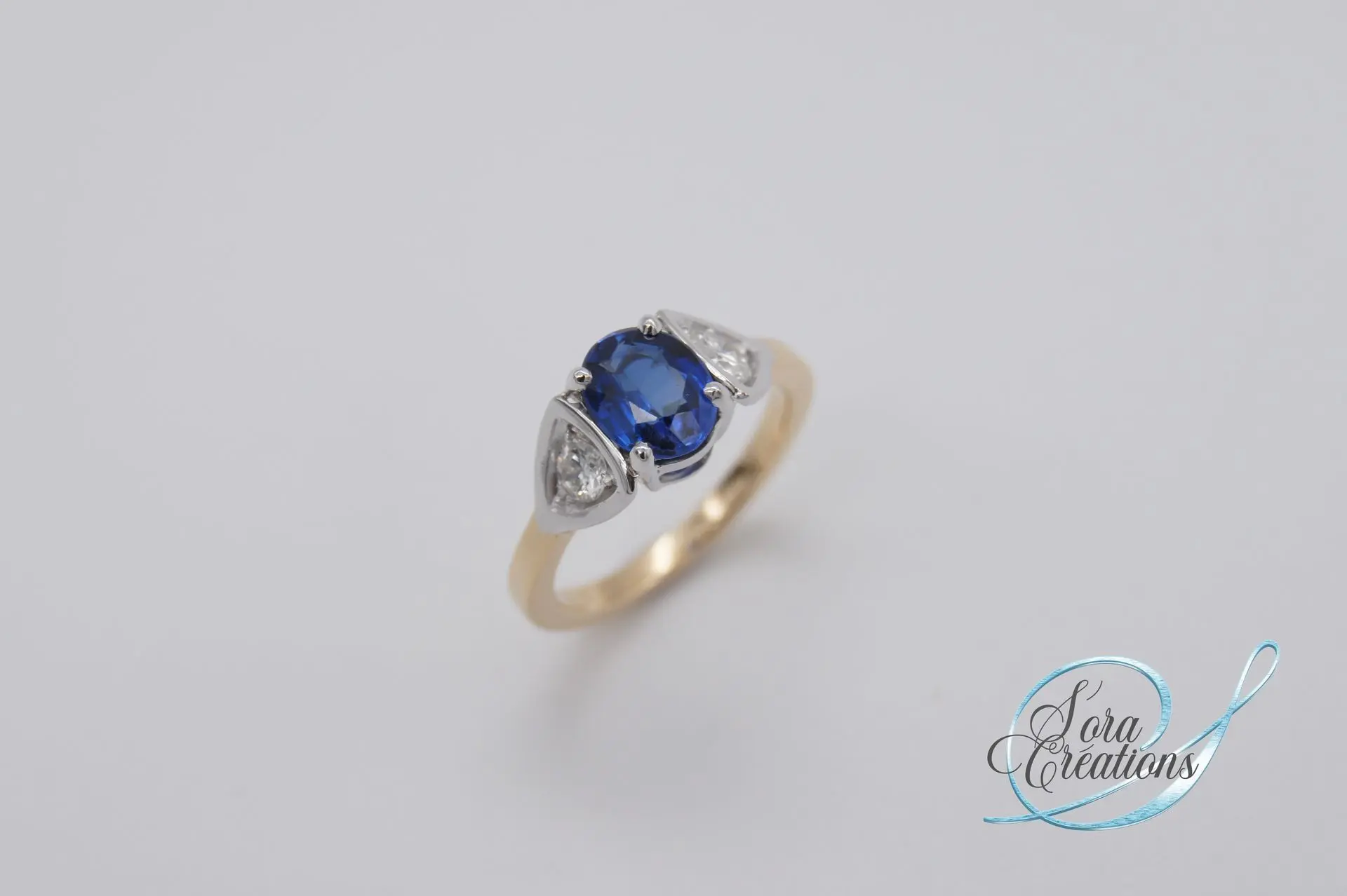 Bague sur-mesure en or jaune et gris avec un saphir et deux diamants