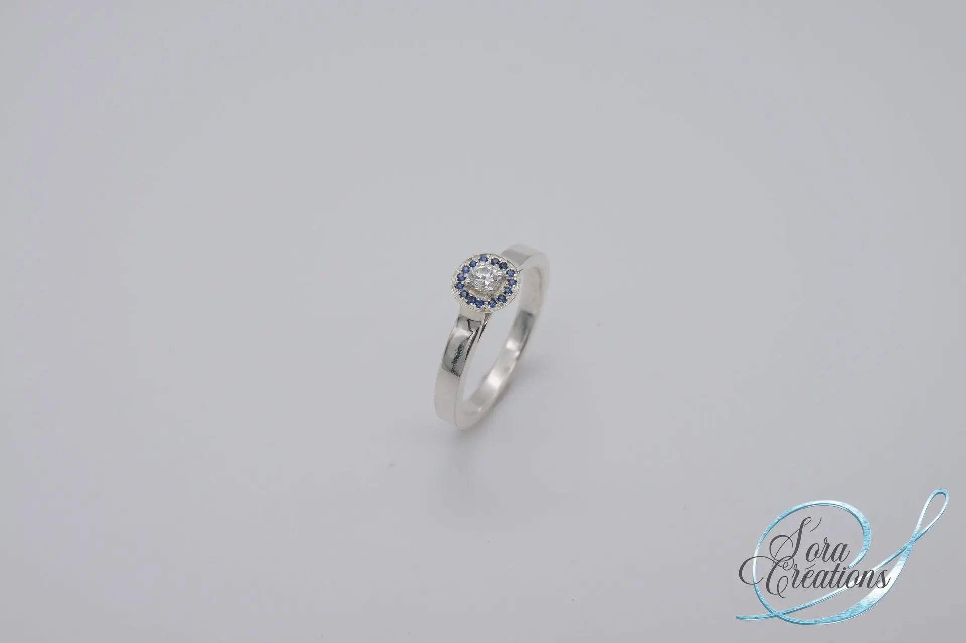 Bague sur-mesure en argent avec un diamant entourage saphirs