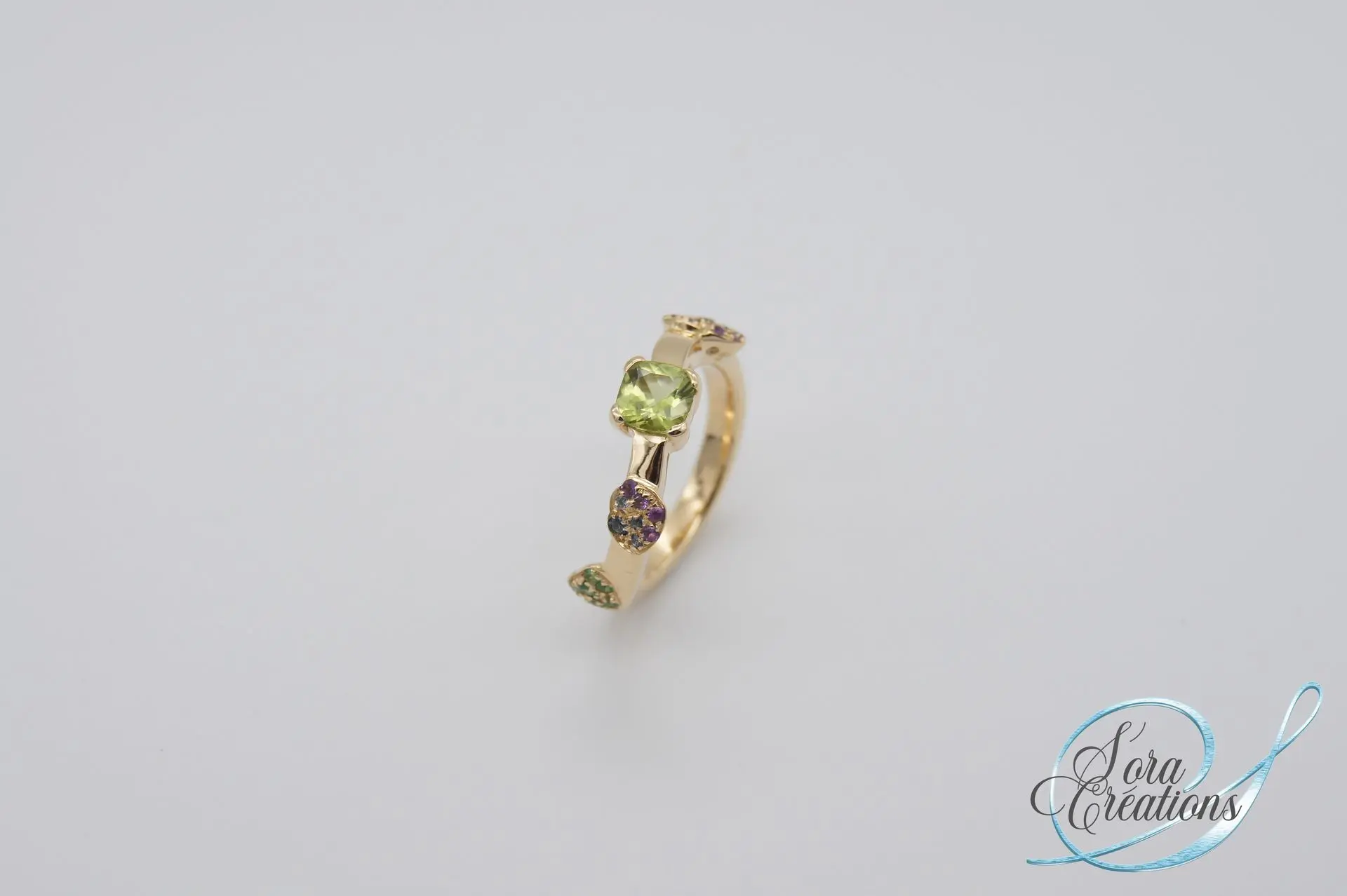 Bague sur-mesure en or jaune motif hortensia avec un péridot et des améthystes et des saphirs