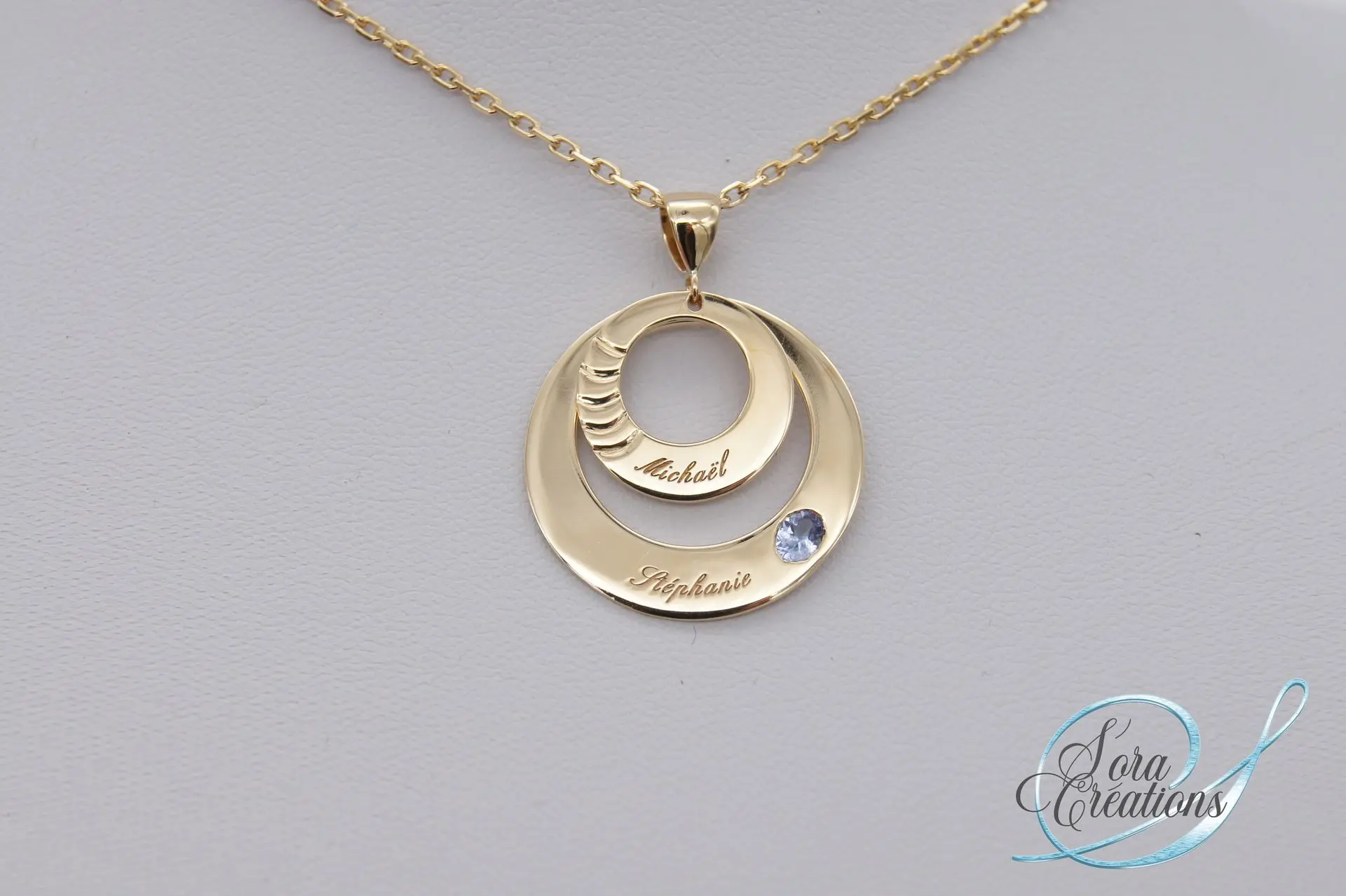 Pendentif or jaune avec un saphir bleu et deux prénoms gravés