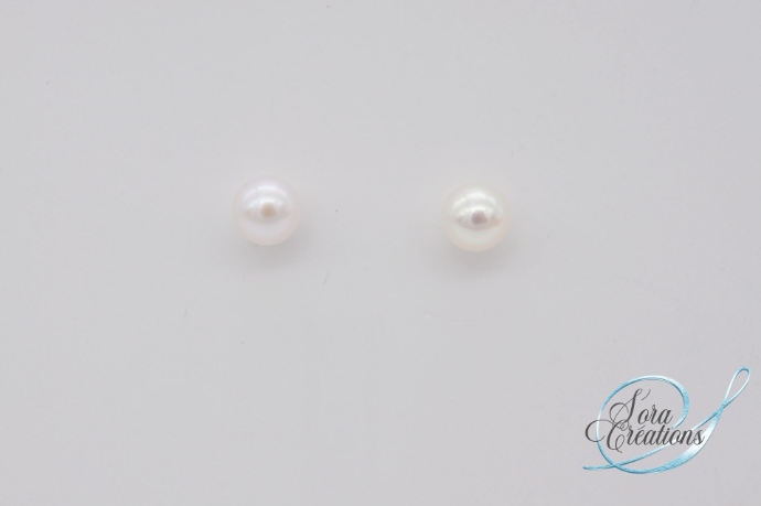 Une paire de boucles d&#39;oreilles avec des perles blanches sur argent