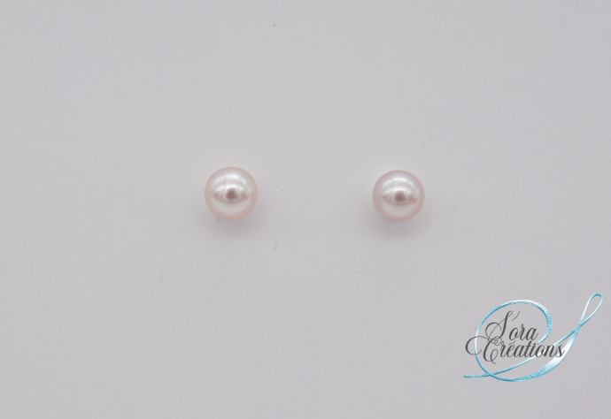 Une paire de boucles d&#39;oreilles avec des perles roses sur argent