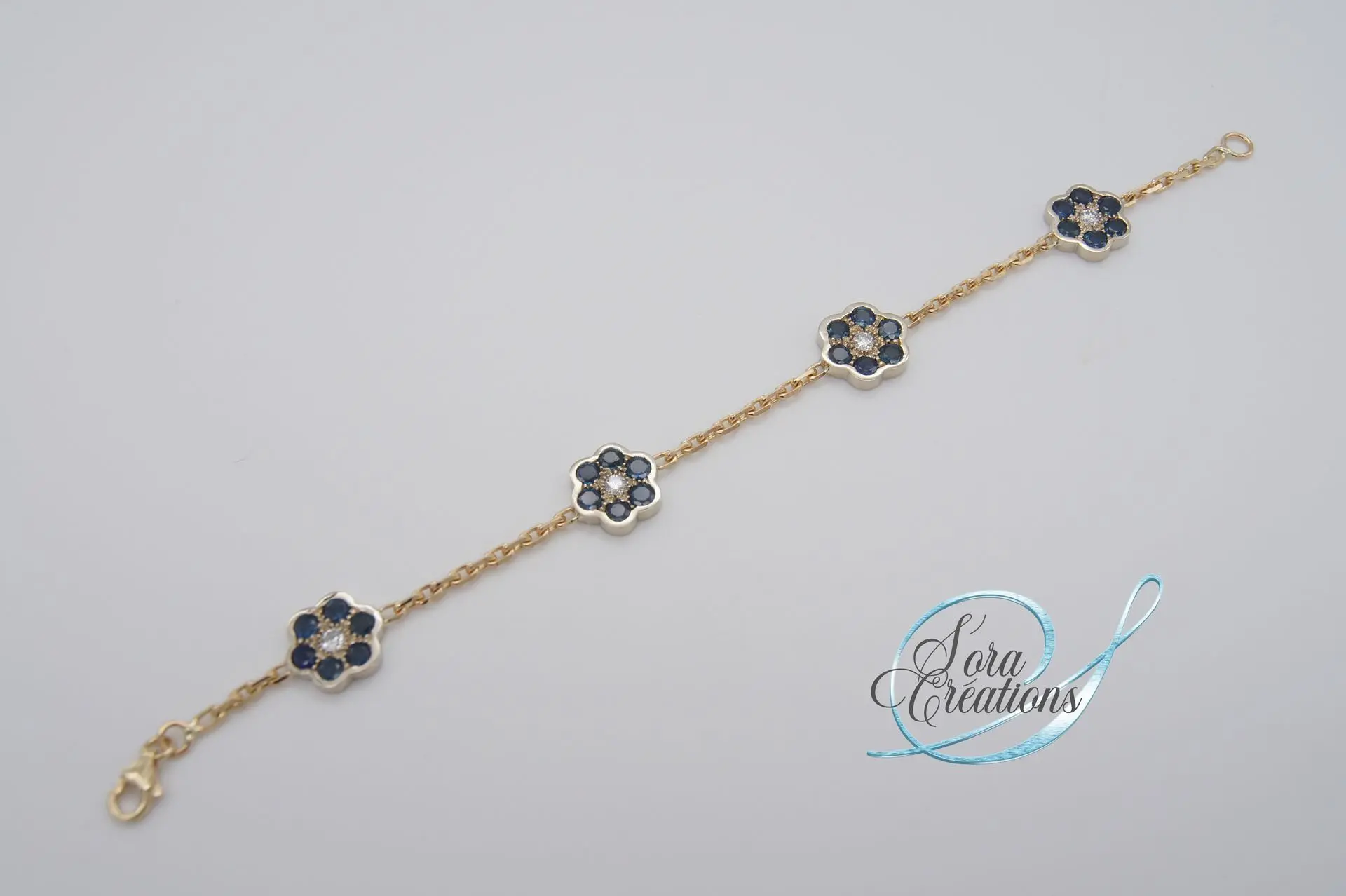 Bracelet or jaune motifs fleurs or gris avec des saphirs et des diamants