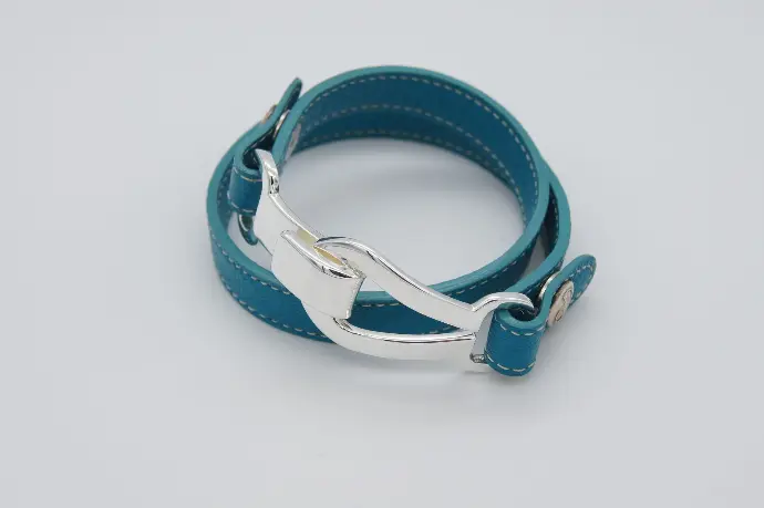 Un bracelet de la marque De Percin avec une lanière en cuir et une boucle en argent