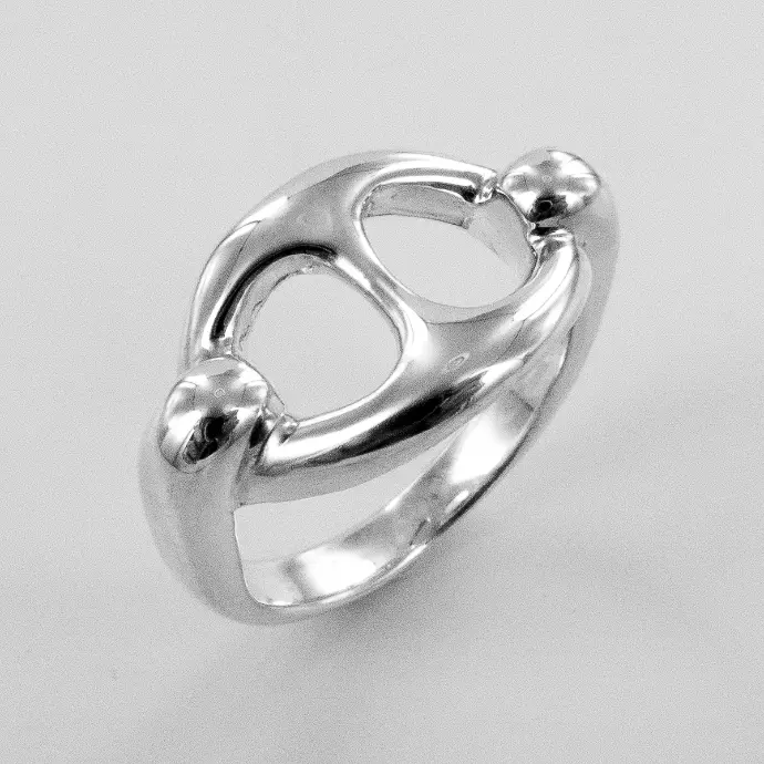 Une main portant une bague de la marque De Percin touche une fleur jaune